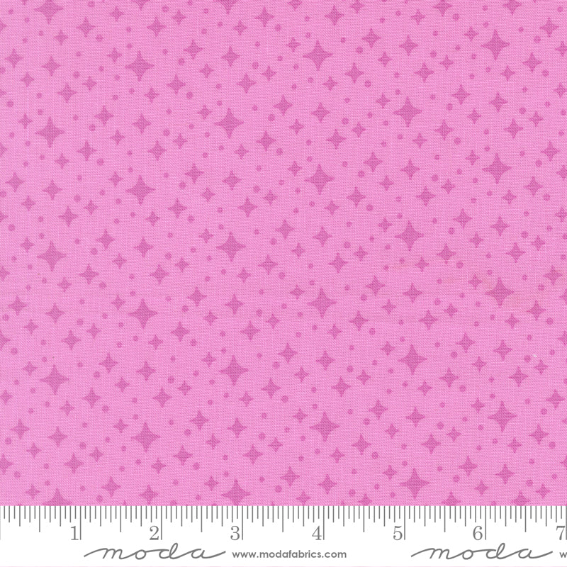 Pink fabric with star pattern and a ruler for scale