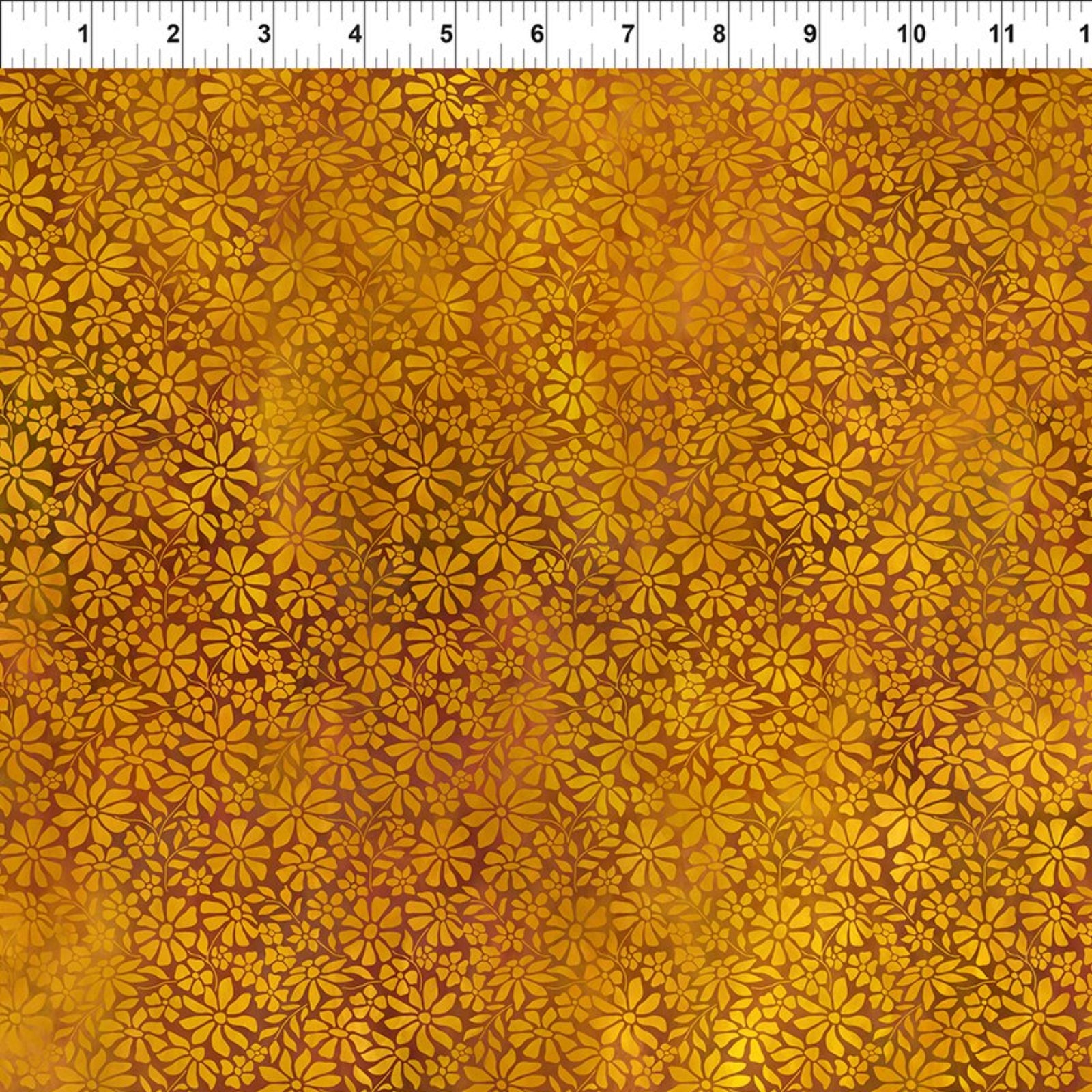 A close-up of a fabric or material swatch with an allover repeating floral/daisy pattern in warm golden yellow, amber, and brown tones. A white ruler with black measurement markings is visible along the top edge, indicating scale.