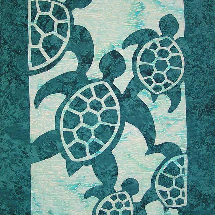 Appliqué quilt featuring five stylized sea turtles in dark teal on a lighter aqua background.