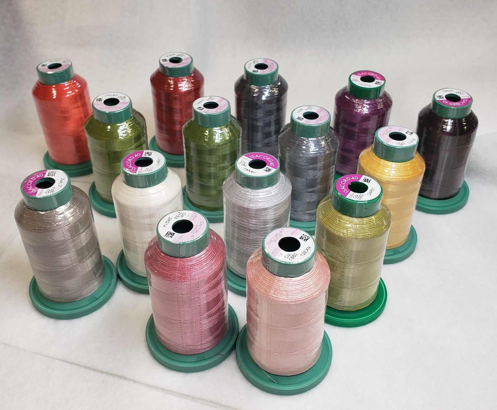 A collection of 15 spools of sewing thread in various colors