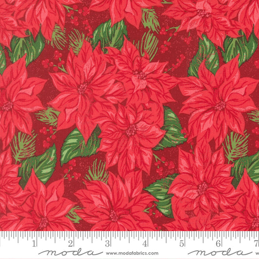 Red poinsettia floral fabric pattern with green leaves on a red background, featuring a ruler for scale.