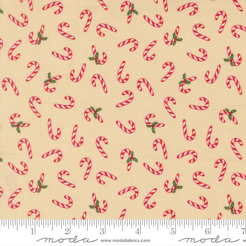 Pattern of red candy canes with green leaves on a beige background, featuring a ruler for scale
