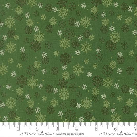 Green fabric with snowflake pattern and ruler for scale