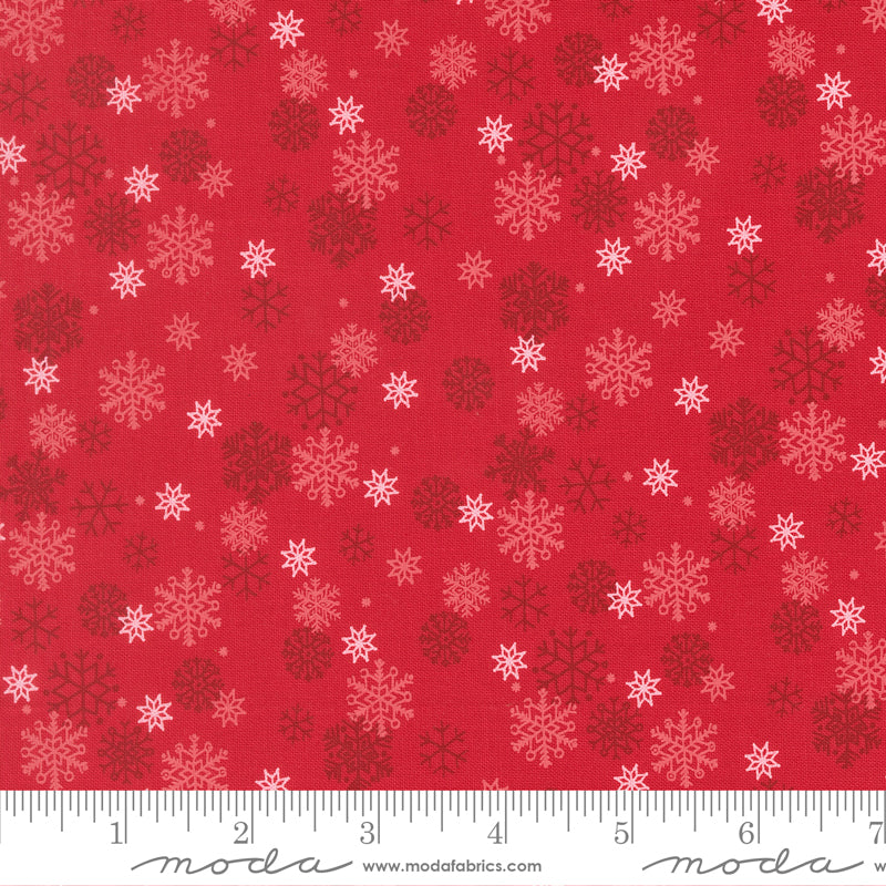 Red fabric with snowflake pattern and ruler for scale