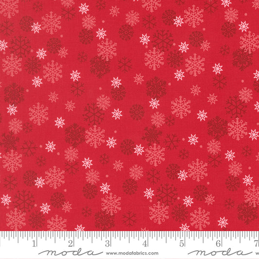 Red fabric with snowflake pattern and ruler for scale