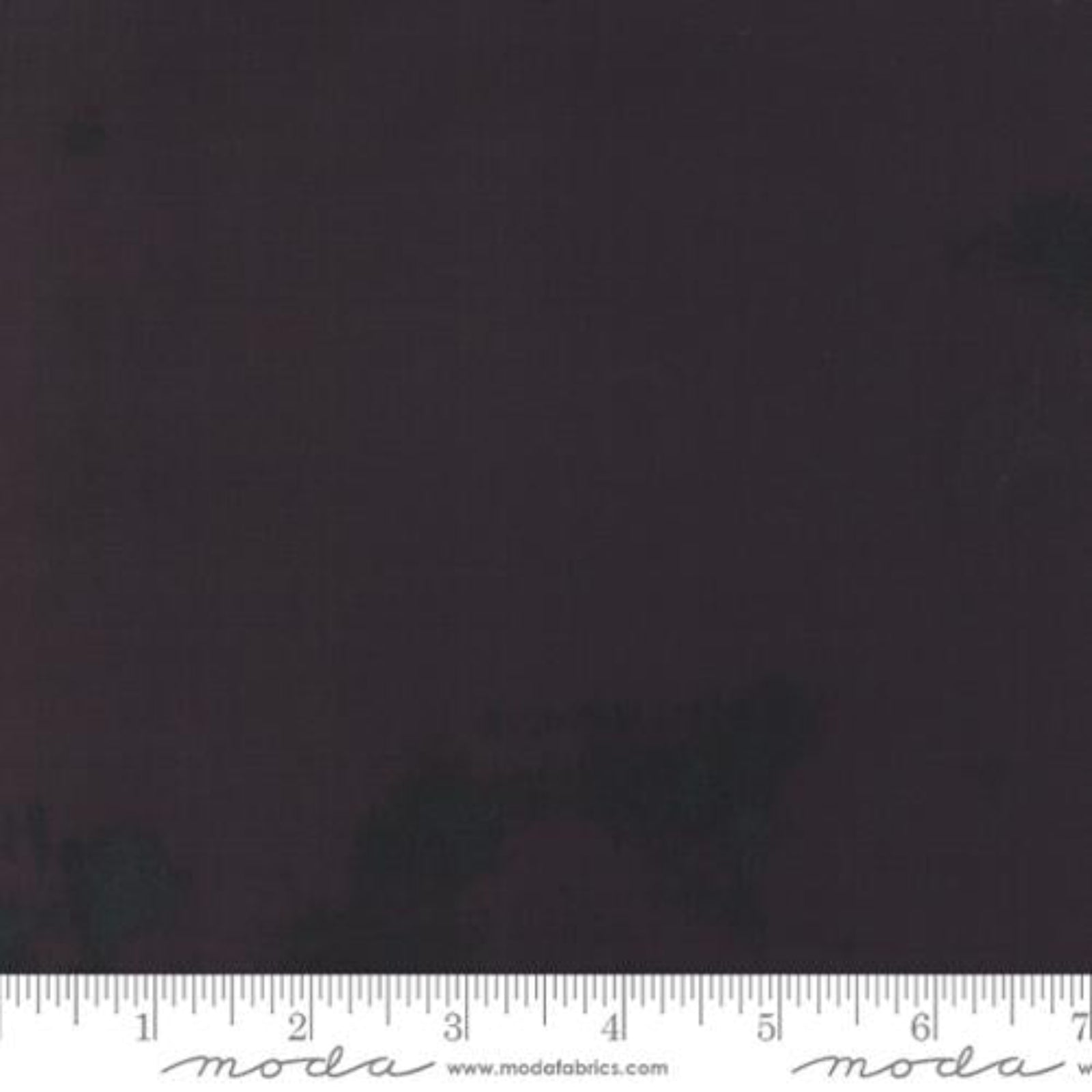 Solidish black fabric swatch with a ruler at the bottom