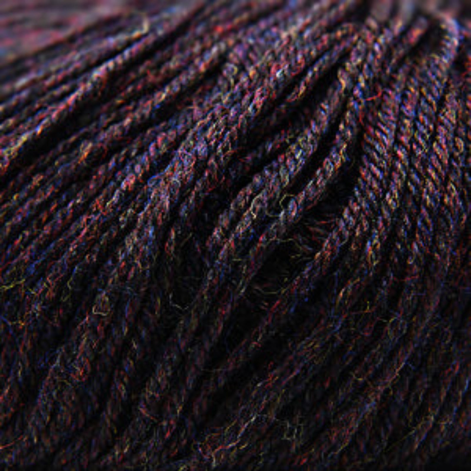 Close-up of dark blue yarn with red speckles