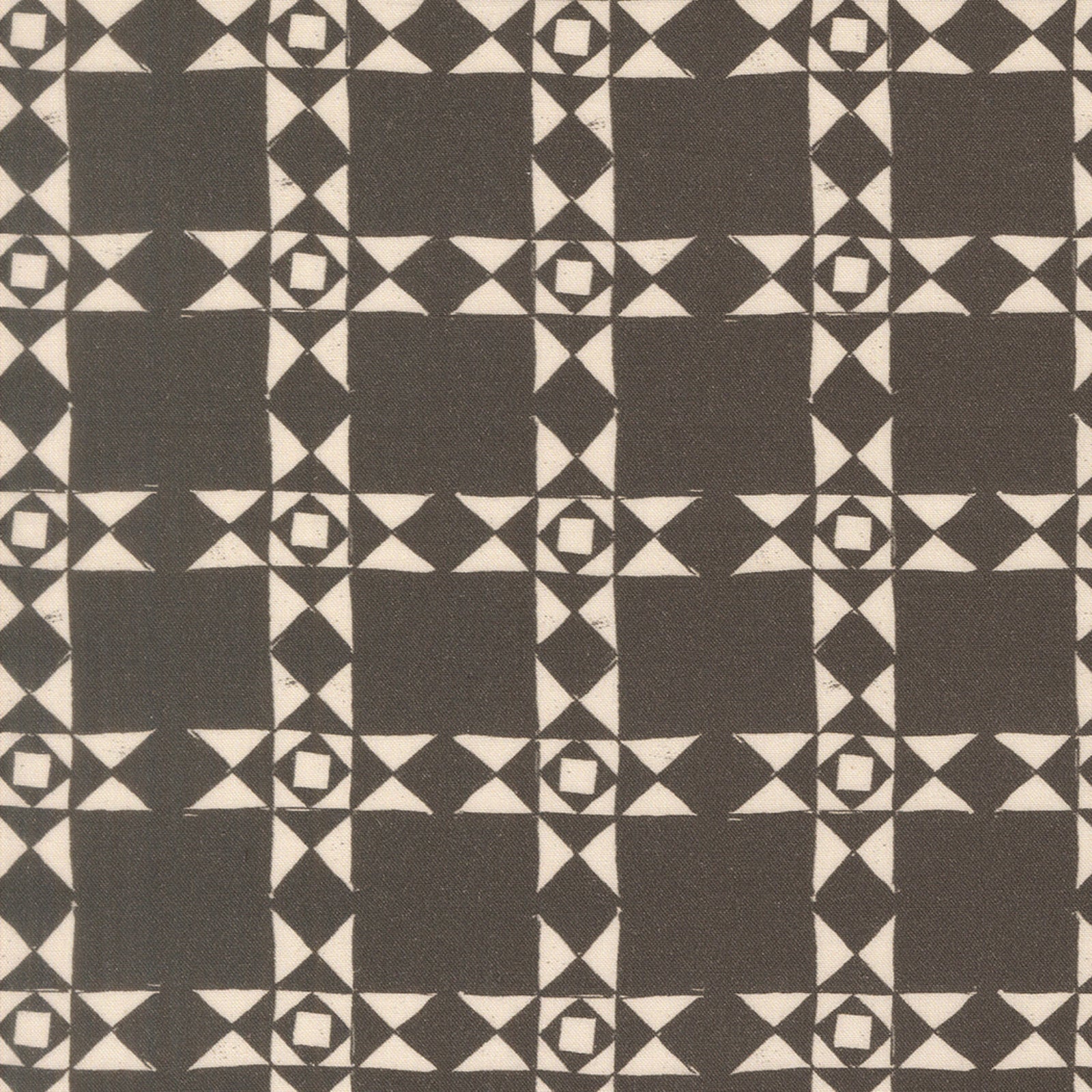A close-up of a fabric pattern featuring a repeating geometric design of dark brown squares, diamonds, and triangles on a warm cream background.