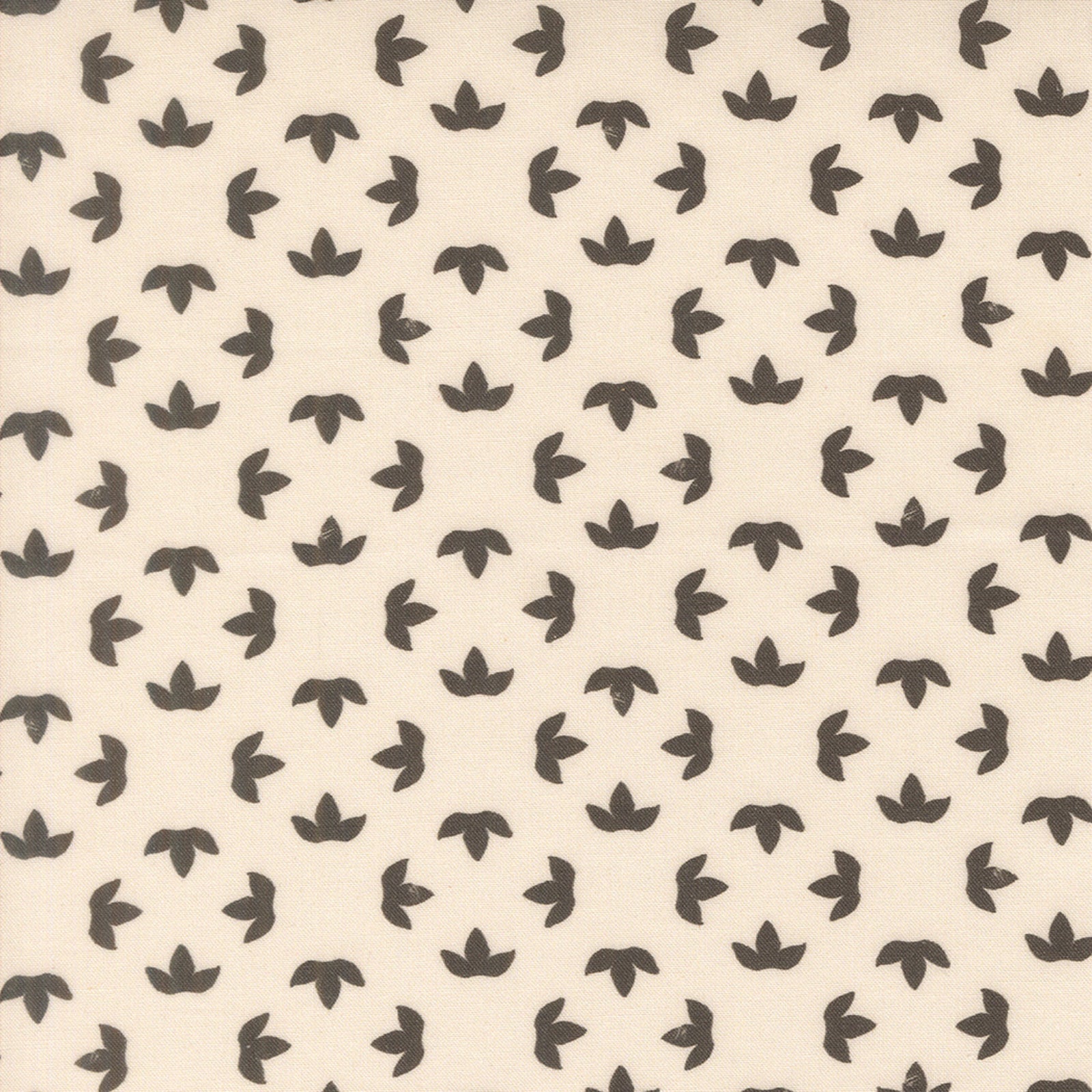 A close-up of a fabric pattern featuring a repeating motif of small dark gray stylized flower or leaf shapes on a warm cream background.