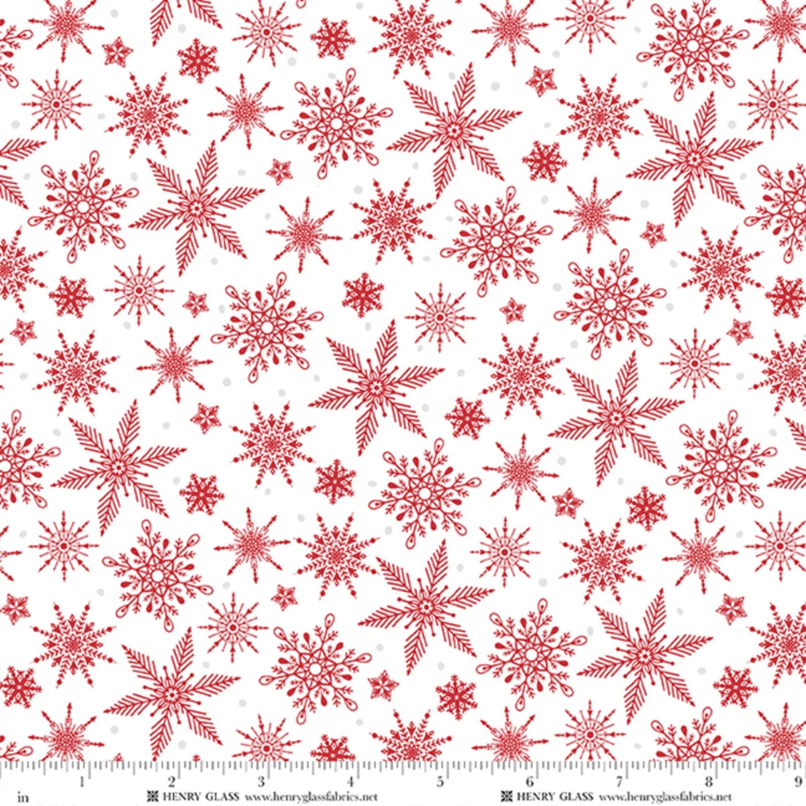 Red snowflake patterned fabric on a white background with a measuring ruler along the bottom edge showing scale.