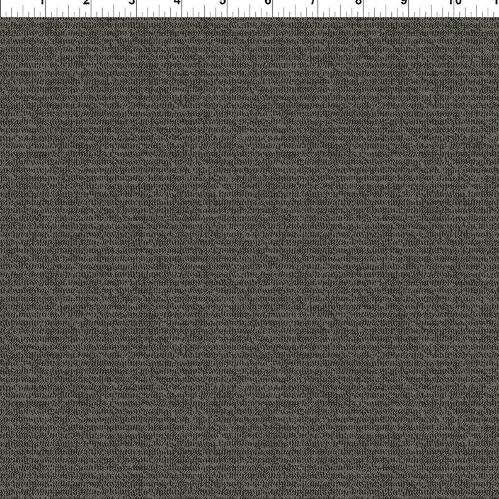 A close-up of a dark charcoal gray textured fabric with a fine woven pattern, shown with a white ruler at the top edge for scale.