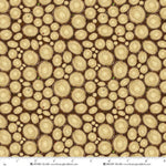 A repeating pattern of overlapping tree trunk cross-sections in warm beige and tan tones on a dark brown background, with a ruler scale and the brand name Henry Glass visible along the bottom edge.