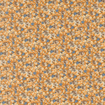 A close-up of a repeating floral pattern featuring mustard yellow and cream flowers with brown centers and small blue accents.