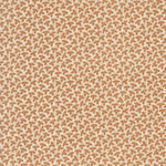 A close-up of a repeating fabric pattern featuring small brown leaf motifs on a warm cream background.