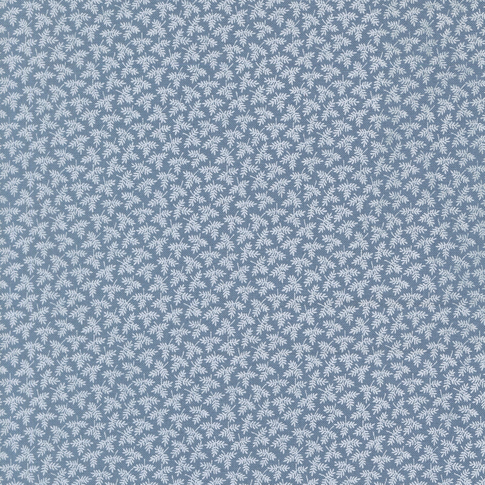 A close-up of a fabric featuring a repeating small leaf motif on a dusty blue background.