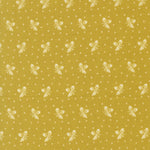 A close-up of a fabric pattern featuring a mustard yellow background with a repeating design of small white butterflies and tiny white dots.