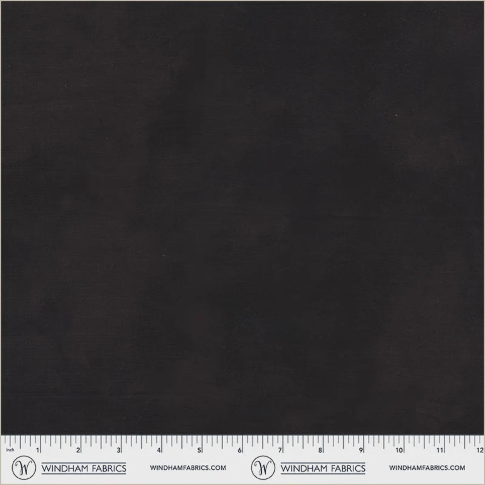 A close-up of a dark charcoal gray fabric texture with a white ruler at the bottom displaying measurements and the Windham Fabrics logo.