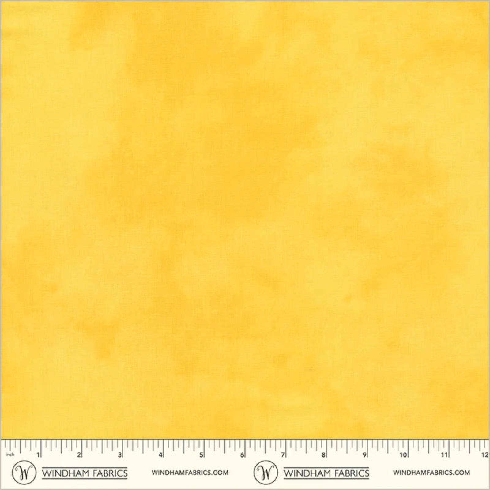 A square fabric sample in a warm golden yellow color, with a printed ruler scale along the bottom edge and Windham Fabrics branding.