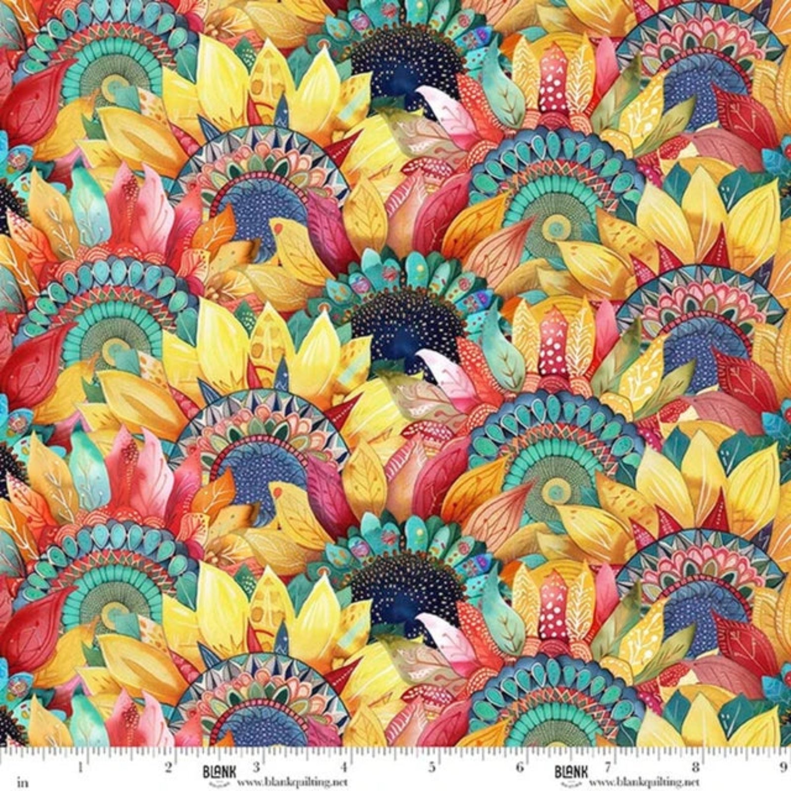 A close-up of a colorful floral fabric pattern with repeating sunflower-like petals and ornate circular mandala motifs in yellow, teal, coral, pink, orange, and dark blue. A white ruler strip with BLANK branding appears along the bottom edge to show scale.
