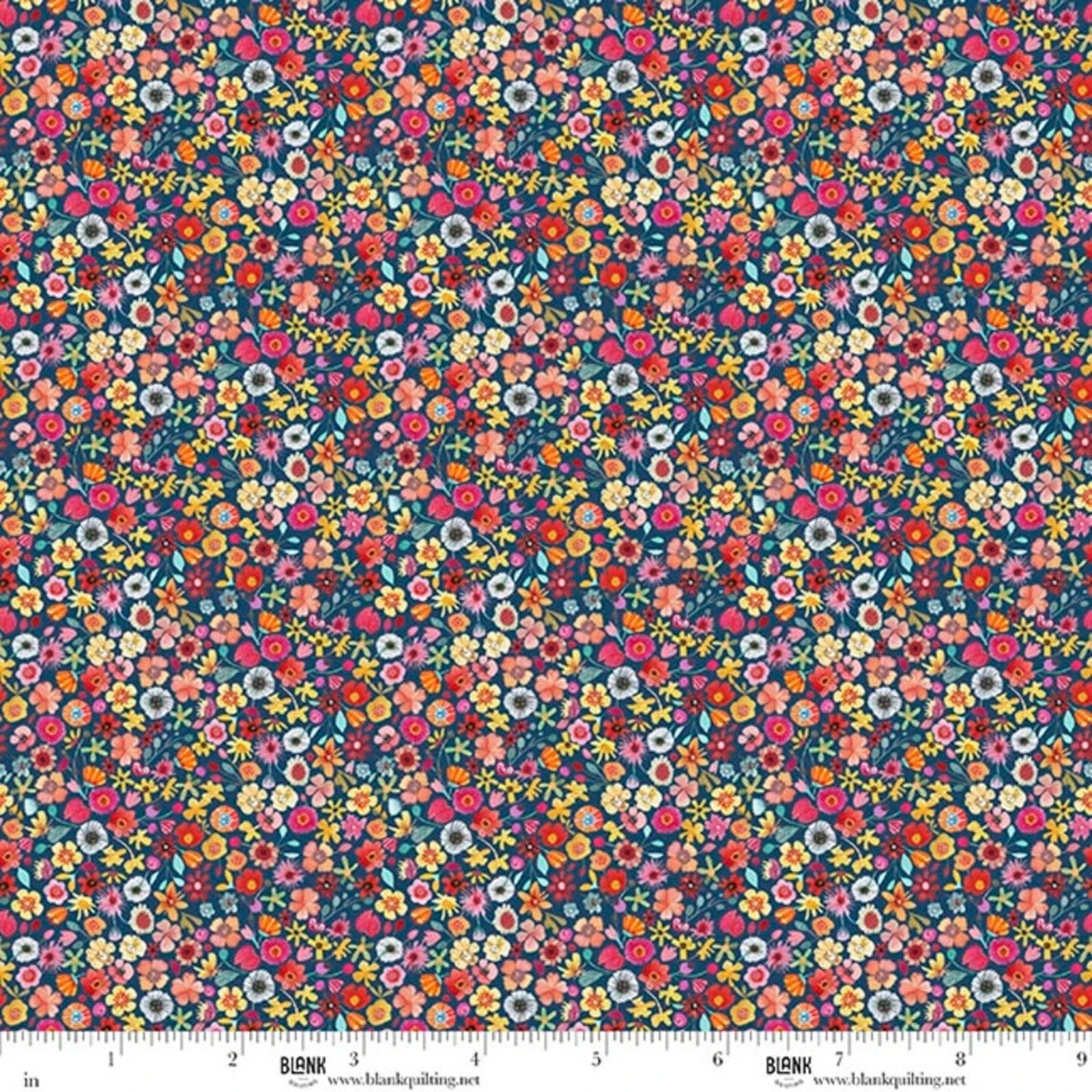 A close-up of a dense floral fabric pattern with small multicolored flowers on a dark blue background, shown with a measurement ruler along the bottom edge. The brand name BLANK is visible on the ruler.