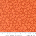 Patterned fabric with red flowers on an orange background.