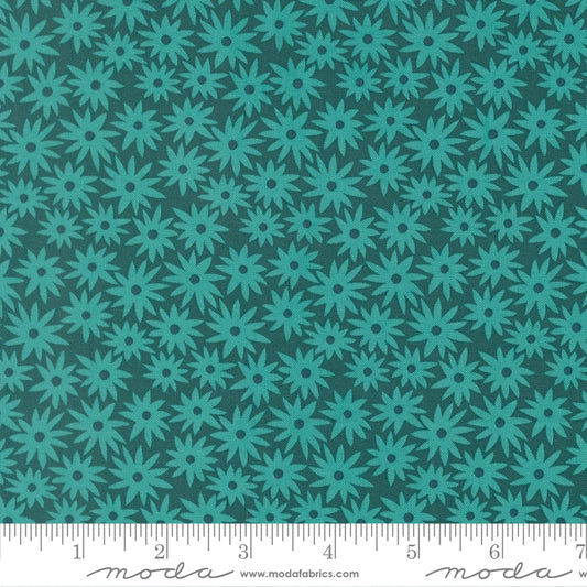 Teal floral pattern on a dark green background with a ruler for scale.