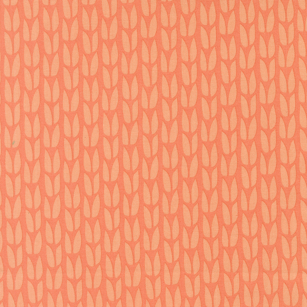 Patterned fabric with a subtle leaf design on a peach background
