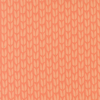 Patterned fabric with a subtle leaf design on a peach background