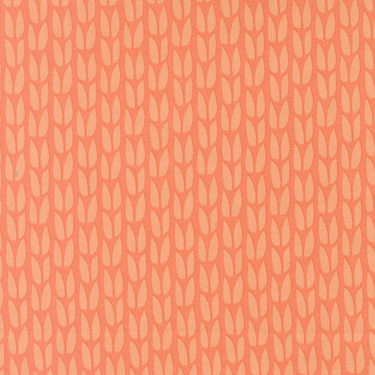 Patterned fabric with a subtle leaf design on a peach background