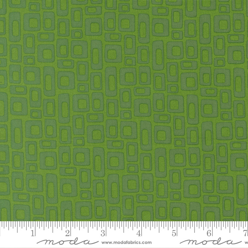 Green fabric with geometric pattern and ruler for scale