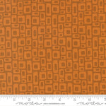 Patterned fabric with geometric shapes on a brown background, featuring a ruler at the bottom for scale.