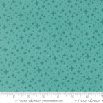 Teal fabric with star pattern with a ruler for scale