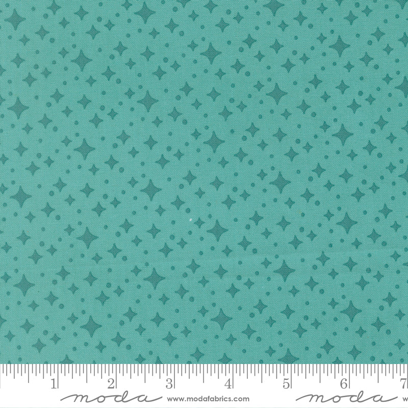 Teal fabric with star pattern with a ruler for scale