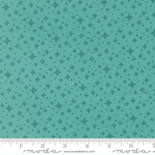 Teal fabric with star pattern with a ruler for scale