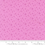 Pink fabric with star pattern and a ruler for scale 