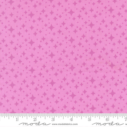 Pink fabric with star pattern and a ruler for scale 