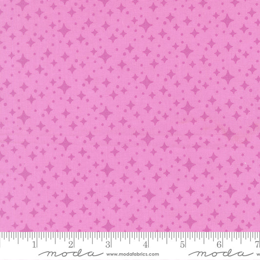 Pink fabric with star pattern and a ruler for scale 