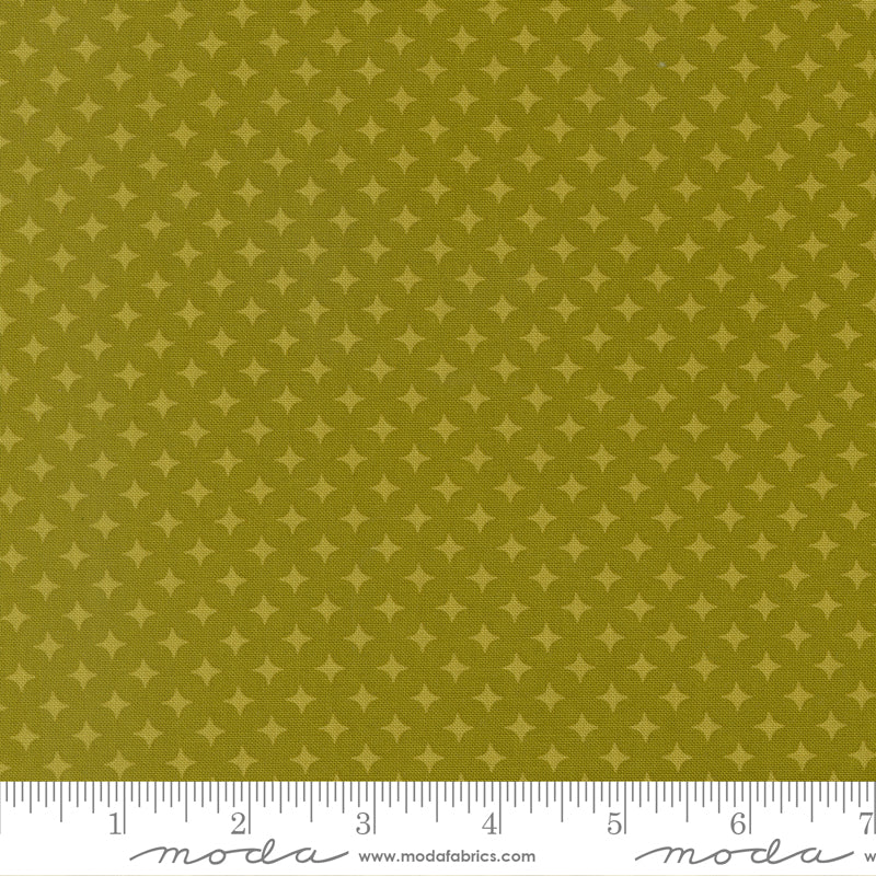 Fabric with star pattern on a green background, featuring a ruler for scale