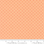 Patterned fabric with a small diamond design on a peach background, featuring ruler for scale
