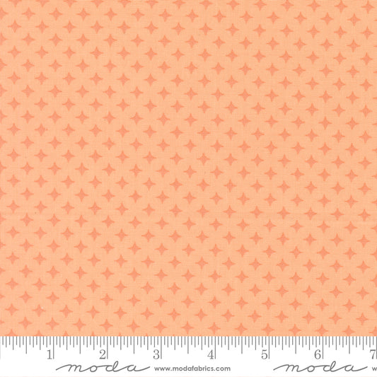 Patterned fabric with a small diamond design on a peach background, featuring ruler for scale