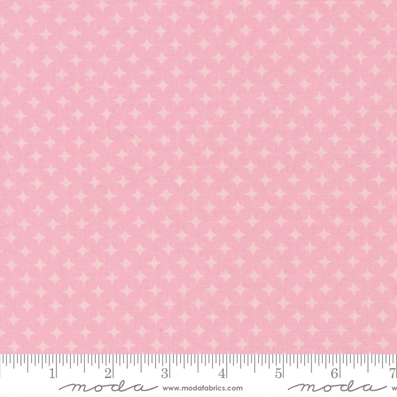 Pink fabric with a subtle pattern and Moda label, featuring a ruler at the bottom.