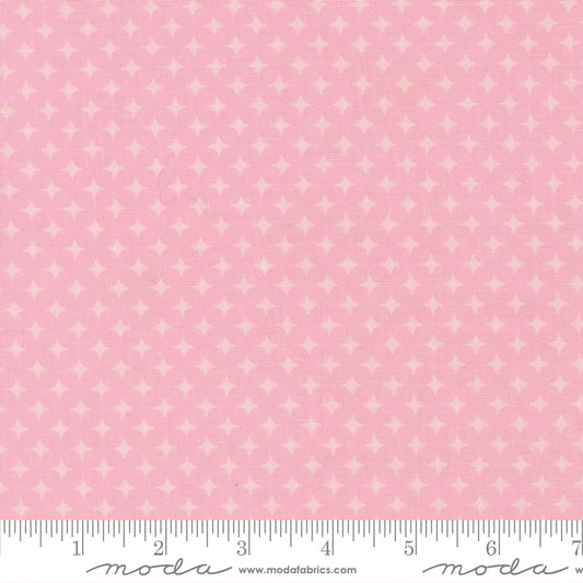 Pink fabric with a subtle pattern and Moda label, featuring a ruler at the bottom.