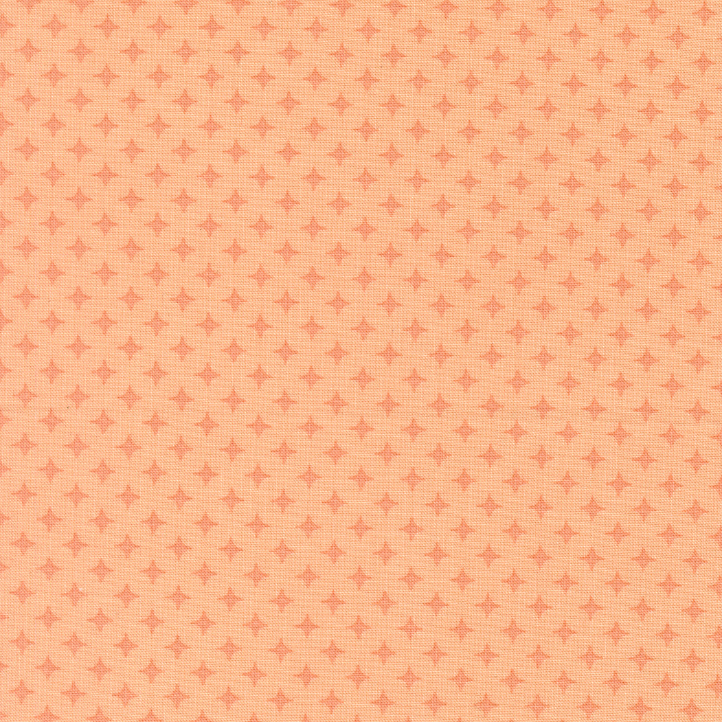 Patterned fabric with small diamond shapes on a peach background