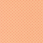 Patterned fabric with small diamond shapes on a peach background