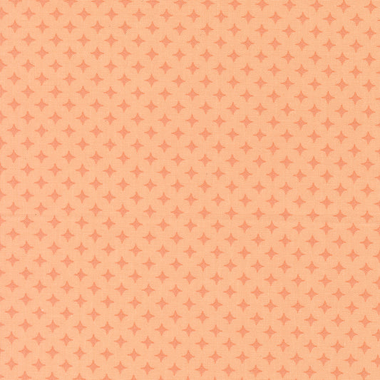 Patterned fabric with small diamond shapes on a peach background