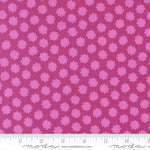Pink floral pattern fabric with a ruler for scale on a pink background