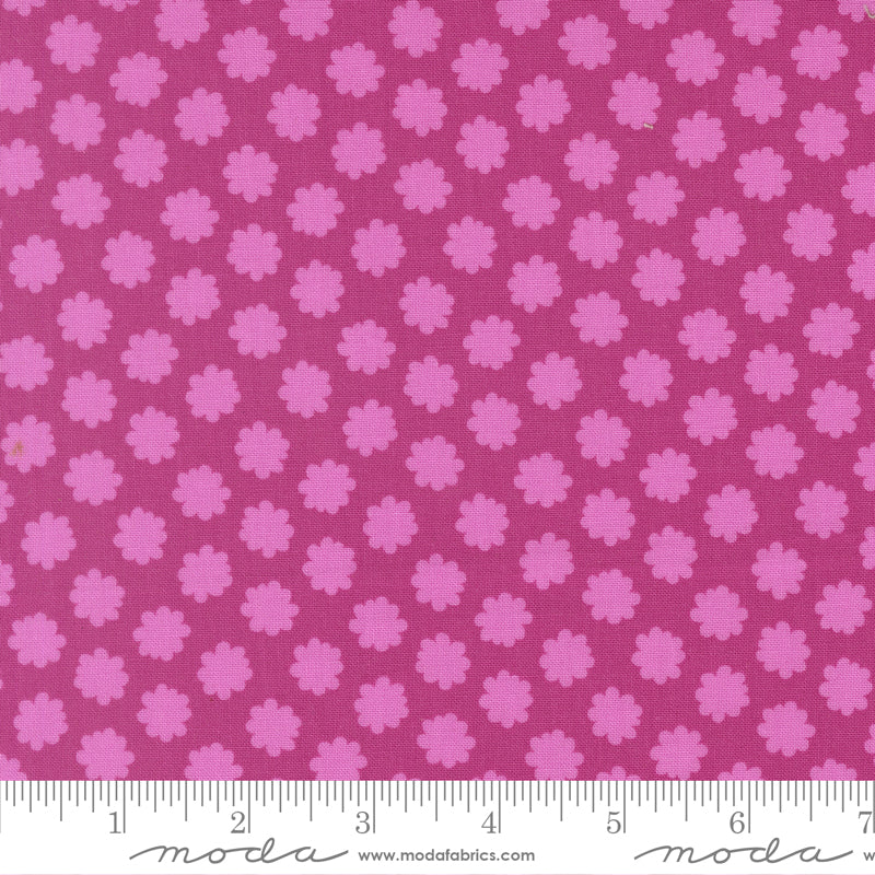 Pink floral pattern fabric with a ruler for scale on a pink background