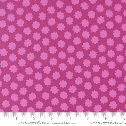 Pink floral pattern fabric with a ruler for scale on a pink background