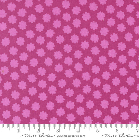 Pink floral pattern fabric with a ruler for scale on a pink background