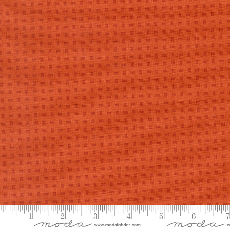 Orange fabric with a subtle pattern and a ruler at the bottom for scale.